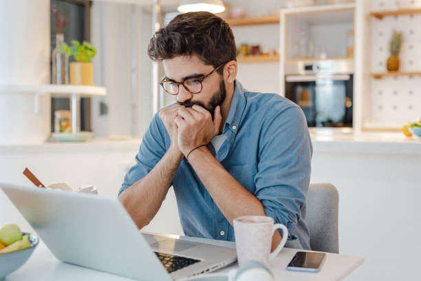 istock Worried man using laptop at home 1372411203