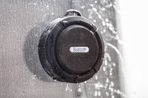 Wireless black bluetooth speaker shower radio in wet shower stock photo
