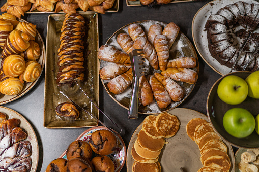 Variety of bread and baked food in bakery corner in luxury hotel breakfast buffet.
