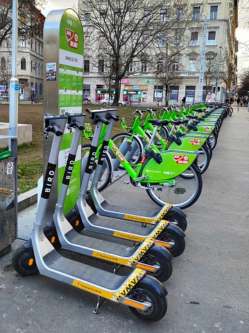 Budapest, Hungary - January 21th, 2022: Rentable micro mobility vehicles: Bird scooters and MOL Bubi bicycles on a mobility point in Budapest, Rakoczi square.