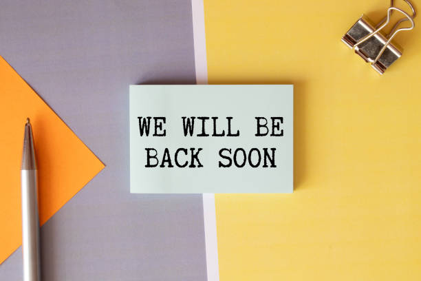 istock WE'LL BE BACK SOON text on notepad with laptop on the white background. 1372422430