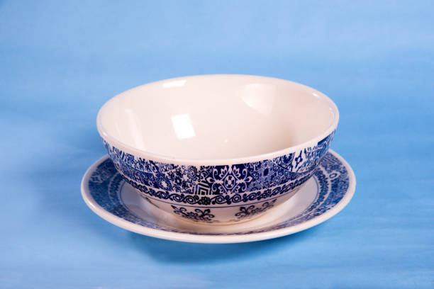 istock white color porcelain cup with designs with handle isolated on light blue background 1372423525