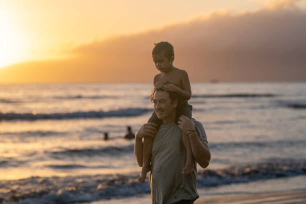 istock Loving dad carrying his son on his shoulders at the beach 1372429475