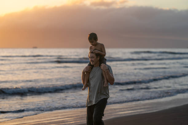 istock Loving dad carrying his son on his shoulders at the beach 1372429480