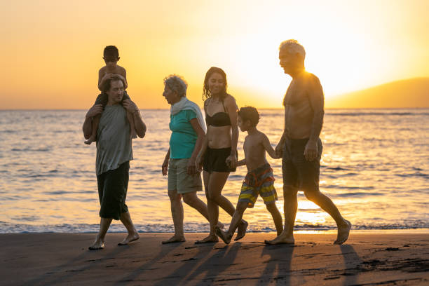 liebevolle mehrgenerationenfamilie, die den sonnenuntergang am strand genießt - family grandmother multi generation family nature stock-fotos und bilder