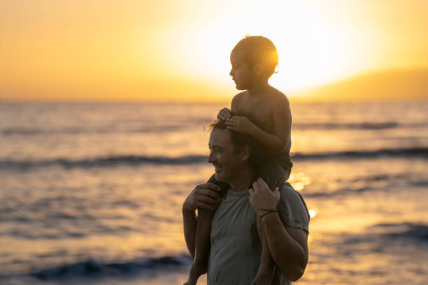 istock Loving dad carrying his son on his shoulders at the beach 1372429500