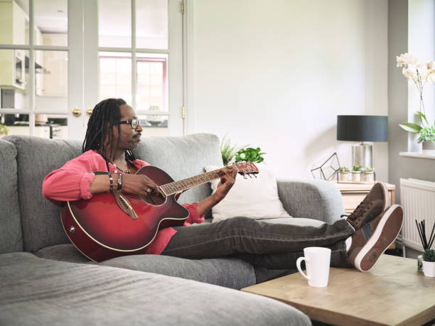 istock Shot of an elderly man having fun while playing the guitar on a sofa at home 1372429933
