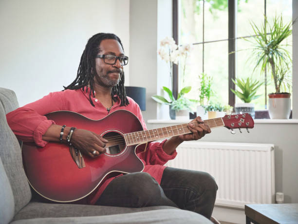 istock Shot of an elderly man having fun while playing the guitar on a sofa at home 1372429961