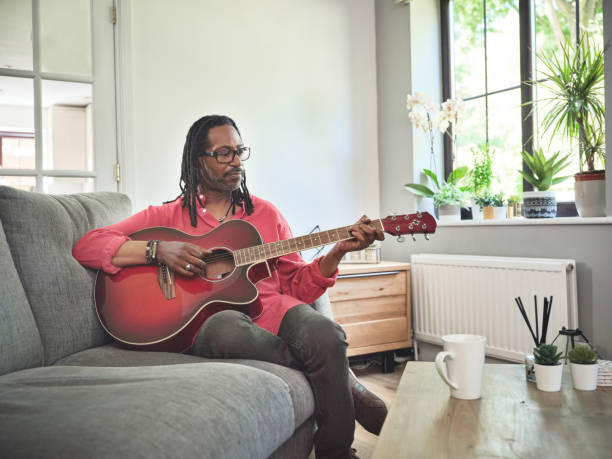 istock Shot of an elderly man having fun while playing the guitar on a sofa at home 1372429969