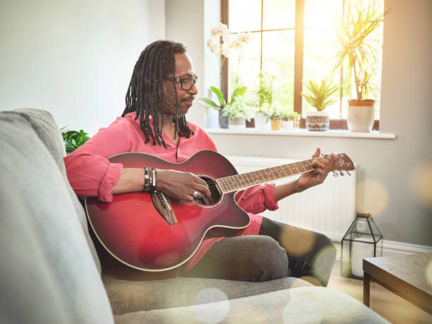 istock Shot of an elderly man having fun while playing the guitar on a sofa at home 1372430482
