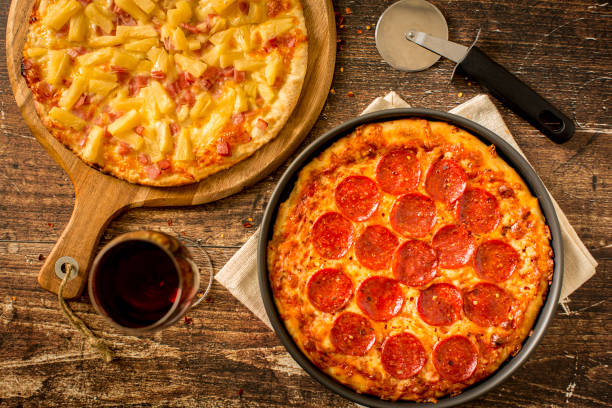 istock Hawaiian pizza and Pepperoni pizza on wood table 1372431888
