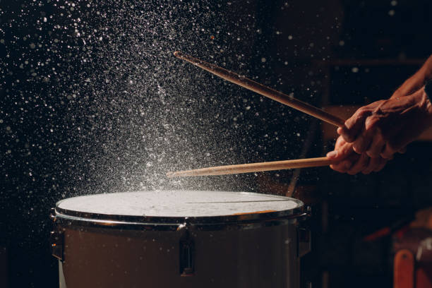 istock Drum sticks drumming beat rhythm on drum surface with splash water drops 1372441216