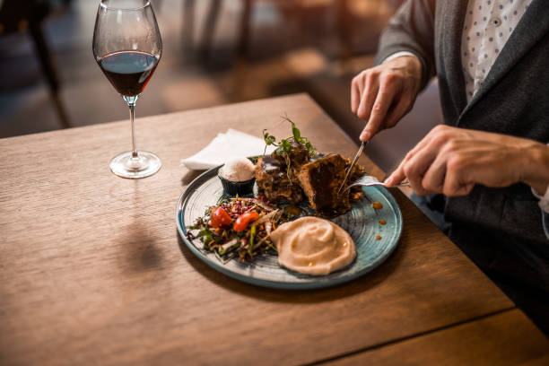 nierozpoznawalny młody człowiek jedzący lunch w restauracji. - restaurant dinner dining gourmet zdjęcia i obrazy z banku zdjęć