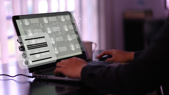 User typing on a laptop with virtual screen of directory contact. Concept for contact us and directory.