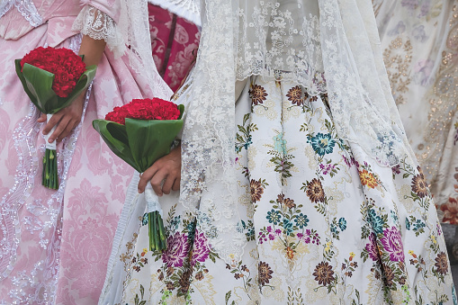 Detail of traditional Spanish floral dresses with flower offering at the celebration 'Fallas', Valencia, Spain