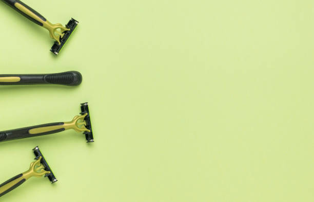 istock Several black and green razors on a green background. Flat lay. 1372449150