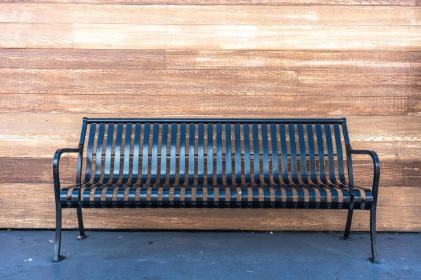 istock Black metal bench with wooden background 1372449311