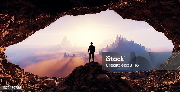 istock Dramatic View of Adventurous Man standing inrocky cave. Mountain Landscape 1372459786