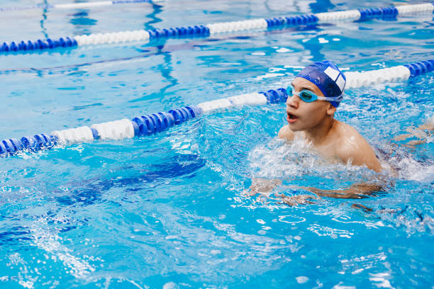 latin jeune homme adolescent nageur athlète portant casquette et lunettes dans un entraînement de natation dans la piscine au mexique amérique latine - swim about photos et images de collection