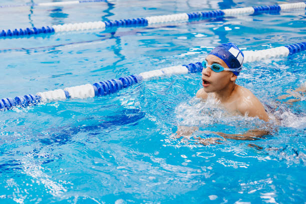 latino giovane atleta nuotatore adolescente che indossa berretto e occhiali in un allenamento di nuoto in piscina in messico america latina - child swimming pool swimming little boys foto e immagini stock