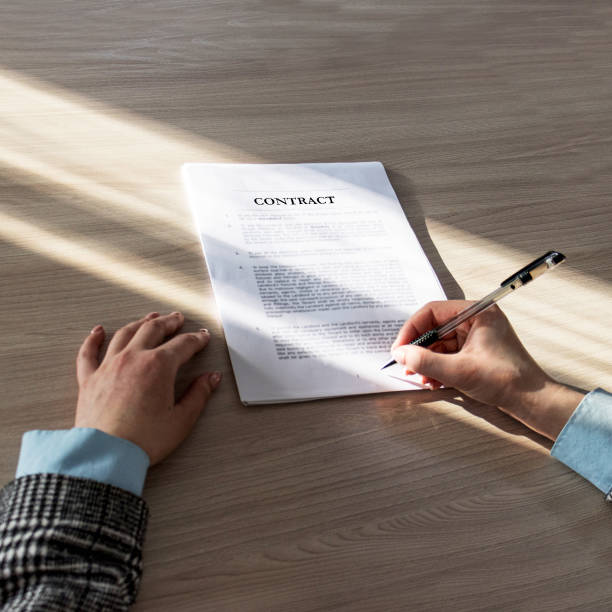 istock A woman examines a contract before signing. 1372465914