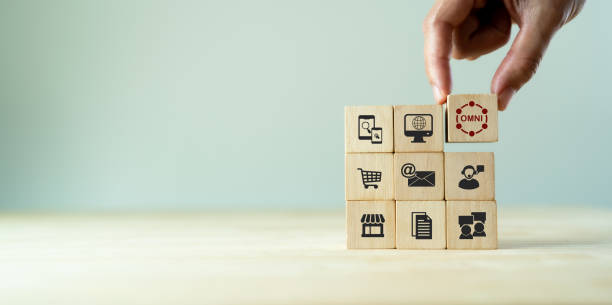 Omnichannel marketing concept. Digital online marketing commerce sale. For customer engagement by integrated online and offline channels. Hand holds wooden cube with omni text standing with omni icon concepto de marketing omnicanal. venta de comercio de marketing digital online. para la participación del cliente mediante canales integrados en línea y fuera de línea. cubo de madera sostenido a mano con texto omni de pie con icono omni