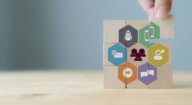 Customer engagement concept.
Technology, internet, business and marketing. Marketing campaign and communication to target customer. Hand  puts wooden cubes with online offline channel for engagement. stock photo