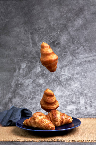 istock Group of croissants falling on a blue plate. Sweets and desserts 1372467167