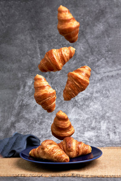 istock Group of croissants falling on a blue plate. Sweets and desserts 1372467268