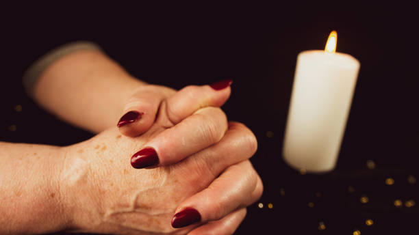 istock Crop woman praying with clasped hands. Crop unrecognizable religious female praying with folded hands at dark table with burning candle 1372467310