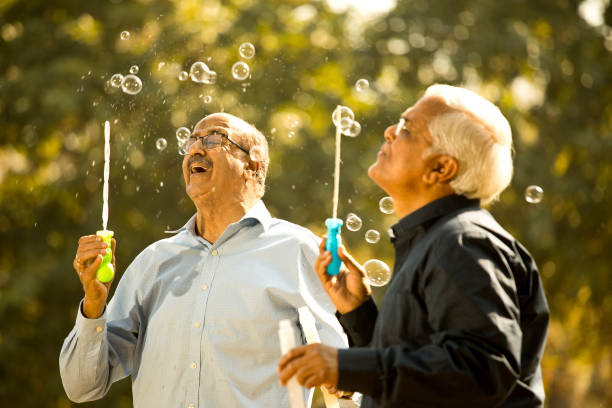 istock Senior men enjoying blowing bubbles at park 1372469920