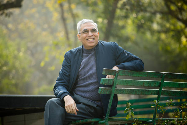 istock Senior man looking away sitting on park bench 1372471288