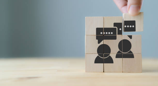consumer feedback concept.  customer satisfaction evaluation to improve and develop product and service. customer centric. hand puts wooden cubes with "feedback" icon on grey background ,copy space. - moppert stockfoto's en -beelden