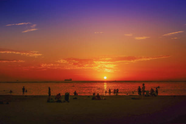 Stunning sunset landscape background with silhouette people at Ala Moana Beach Park in Honolulu city, Oahu island Hawaii