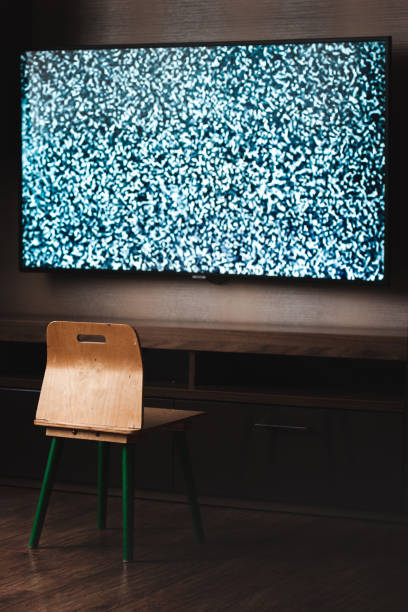 A small child chair in front of a tv with a white noise on the screen. Scary dark creepy horror unsaturated image A small child chair in front of a tv with a white noise on the screen. Scary dark creepy horror unsaturated image. Horror ghost film slenderman fictional character stock pictures, royalty-free photos & images
