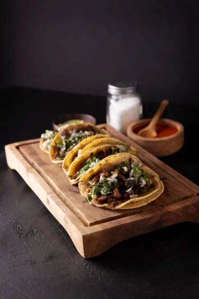 Tacos de Suadero. Fried meat in a corn tortilla. Street food from CDMX, Mexico, traditionally accompanied with cilantro, onion and spicy red sauce