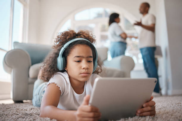 istock Shot of a young girl using a digital tablet while her parents argue 1372477010