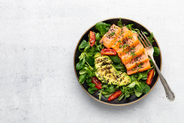 istock Salmon fish fillet with fresh salad, avocado top view. 1372477267