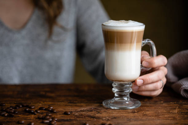 irish coffee with a female hand holding the glass mug - espresso women cup drink imagens e fotografias de stock