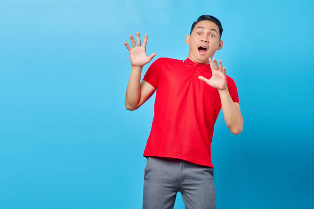 istock Portrait of handsome asian young man looking at copy space with surprised expression looking at big promo isolated on blue background 1372478485