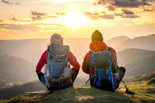 istock Couple sitting and looking at mountain view 1372478562