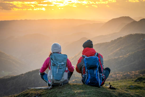 istock Couple sitting on mountain top 1372478586