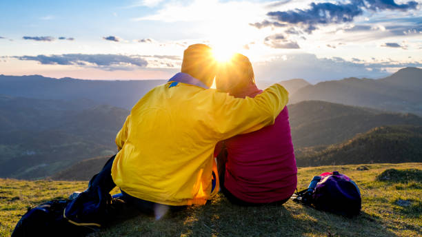 istock Couple sitting and looking at mountain view 1372478618