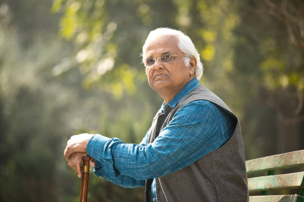 Thoughtful senior man with walking cane at park