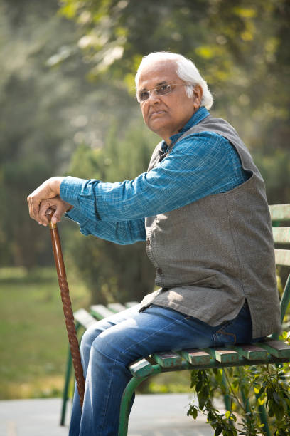 istock Thoughtful senior man with walking cane at park 1372480903