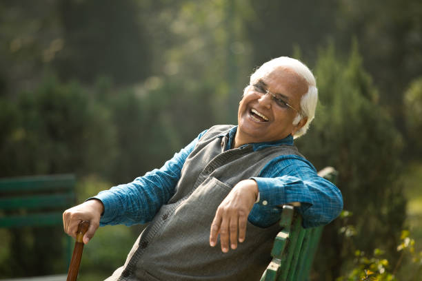 istock Happy senior man sitting at park 1372480922