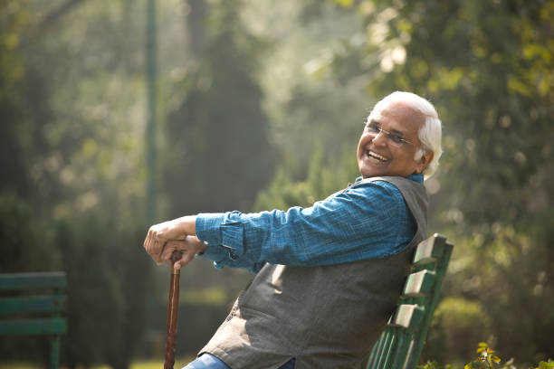 istock Happy senior man sitting at park 1372480948