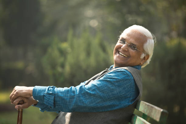 istock Happy senior man sitting at park 1372480975