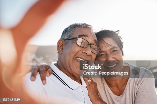 istock Shot of a mature couple taking a selfie at the beach 1372481319