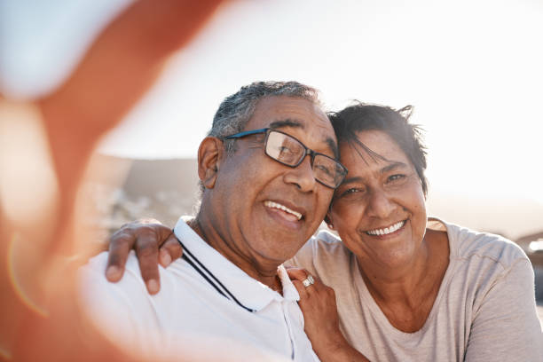zdjęcie dojrzałej pary robiącej selfie na plaży - senior couple senior adult happiness smiling zdjęcia i obrazy z banku zdjęć